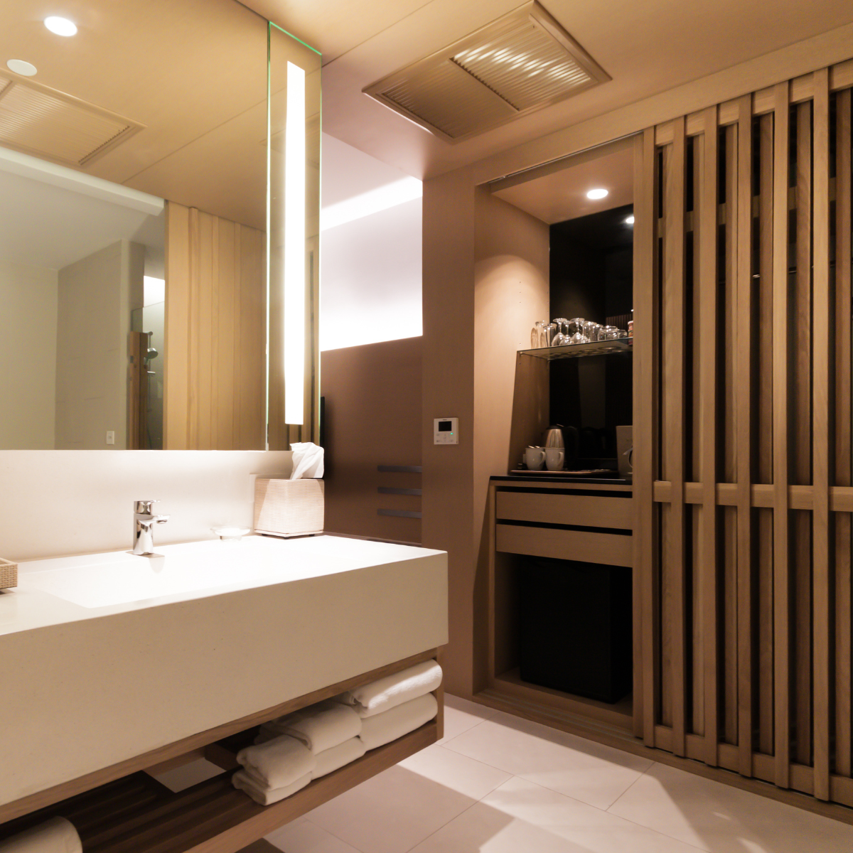 Suite bathroom with stone vanity, warm lighting and timber screen